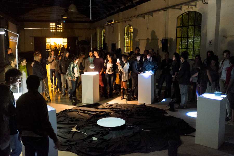 Cave of Sounds exhibited at 90dB Festival of Sonic Arts, Rome 2014. Many people crowd around the circular array of instruments. Photo: Tim Murray-Browne