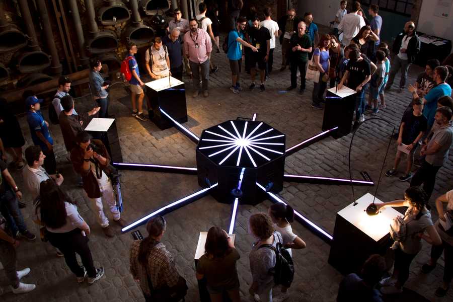 A top down view of Cave of Sounds at Athens Science Festival in 2018 with many people surrounding each instruments