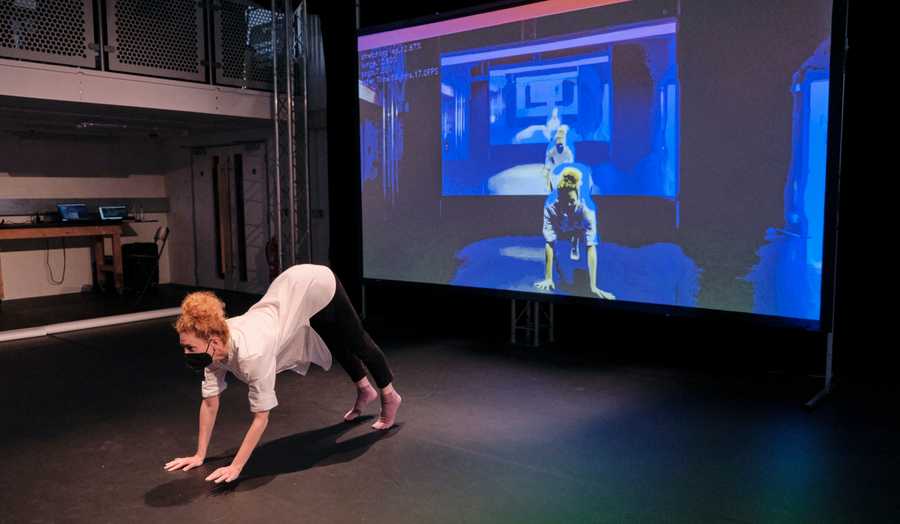 Irini Kalaitzidi dancing in front of a projection screen at Choreographic Coding Lab 14. Photo: Stathis Doganis.